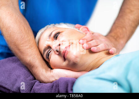 Physical therapist stretching senior woman's neck Stock Photo