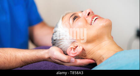 Physical therapist stretching senior woman's neck Stock Photo