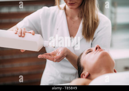 Physical therapist massaging female patient Stock Photo