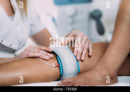 Patient having electrode therapy, or electrical muscle stimulation, on a  knee joint using electrical stimulation to treat muscle pain and prevent  atro Stock Photo - Alamy