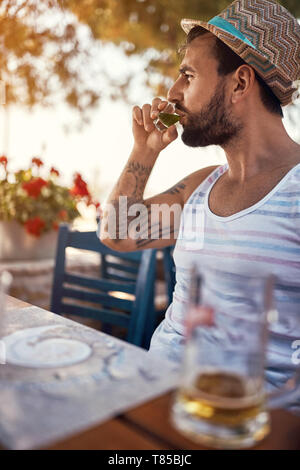 man hipster relaxes and drinking alcohol on vacation Stock Photo