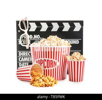 Cups with tasty popcorn, glasses and clapperboard on white background Stock Photo