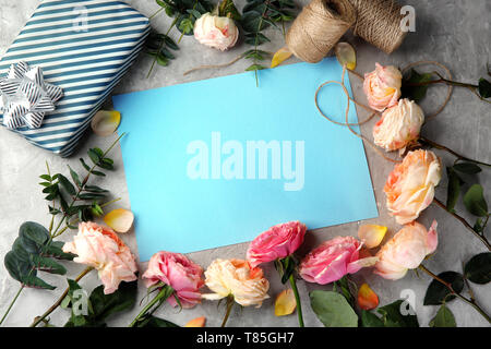Composition with beautiful flowers and blank card on color background Stock Photo