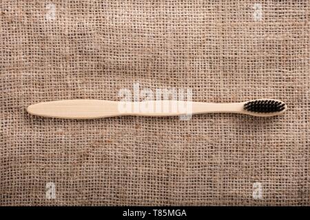 Close-up Of Black Bamboo Toothbrush On Sack Cloth Stock Photo