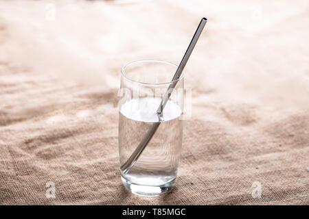 Close-up Of Metal Straw In Transparent Glass Of Water Over The Jute Cloth Stock Photo
