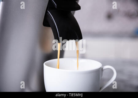 Coffee Maker Pouring Hot Espresso Coffee In White Ceramic Cup Stock Photo