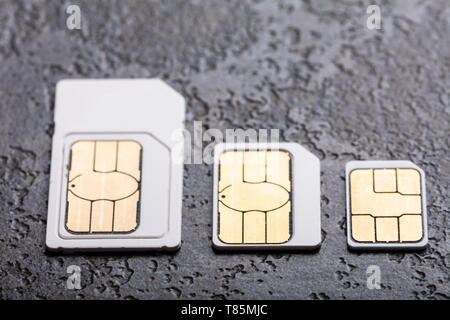 Three Types Of Sim Cards Arranged In A Row Over Concrete Gray Background Stock Photo