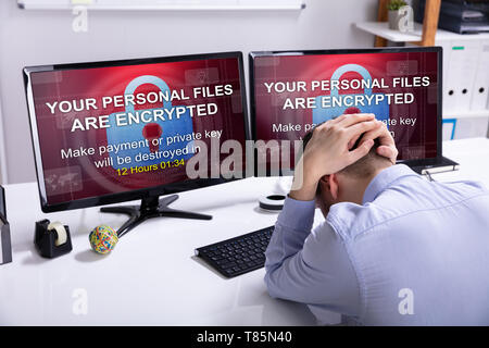 Rear View Of A Sad Businessman With Computer Screen Showing Personal Files Encrypted Text Stock Photo