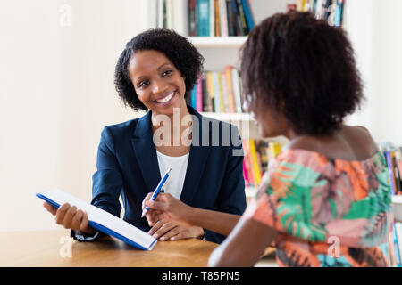 African american applicant signing contract after job interview at office Stock Photo