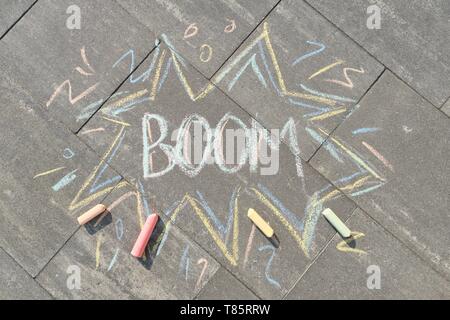 Text Boom drawing crayons on gray asphalt, top view Stock Photo