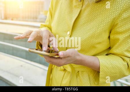 Closeup of womans hand with smartphone, fingers on touchscreen, text message. Stock Photo