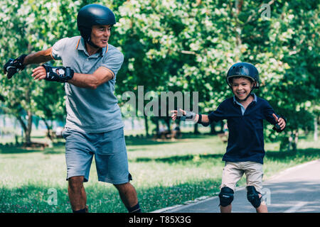 Grandfather and grandson roller skating Stock Photo