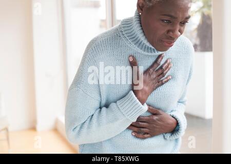 Woman touching chest in pain Stock Photo