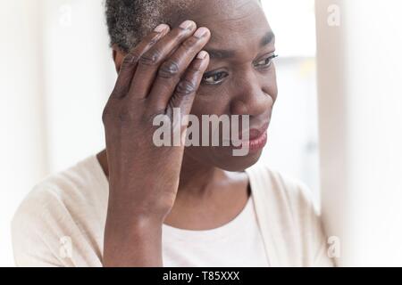 Woman touching head with hand Stock Photo