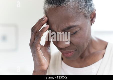 Woman touching head with hand Stock Photo