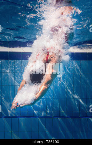 Swimmer diving into pool Stock Photo