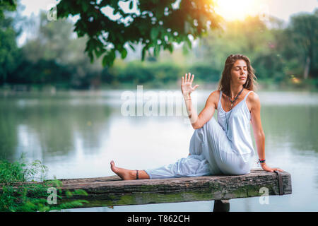 Woman doing yoga by a lake Stock Photo