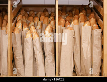 Tasty fresh baguettes on shelf in bakery Stock Photo