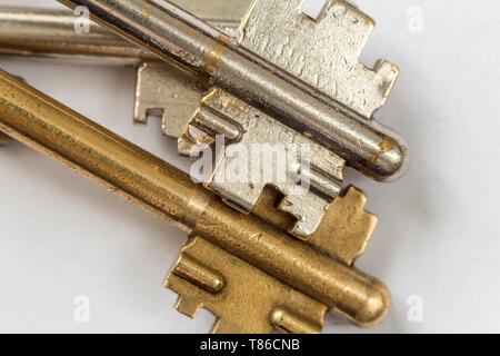 Close-up detail of old metallic keys stainless and yellow isolated on white background. Safety and security concept. Stock Photo
