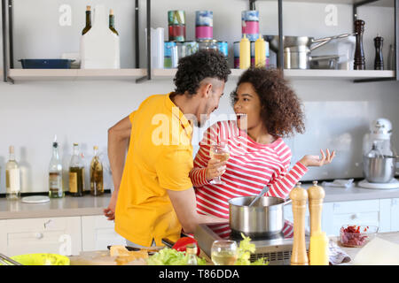 Young African-American couple having fun while cooking in kitchen Stock Photo