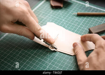 Man working with piece of leather at factory, closeup Stock Photo