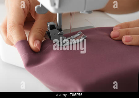 Female tailor using sewing machine, closeup Stock Photo