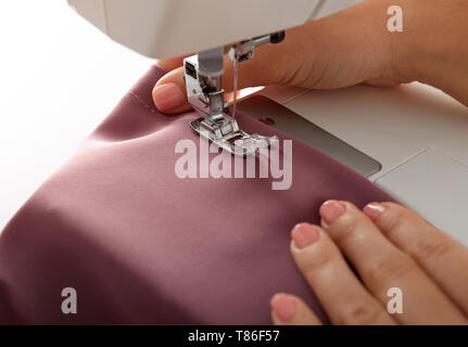 Female tailor using sewing machine, closeup Stock Photo