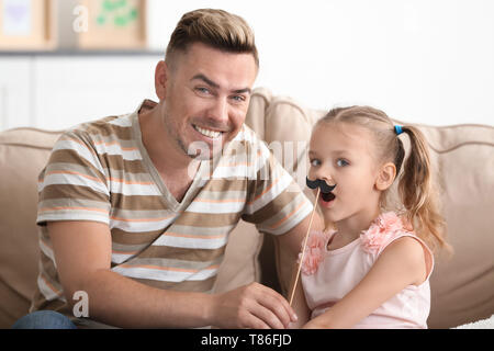 Happy father and daughter playing with party decor at home Stock Photo