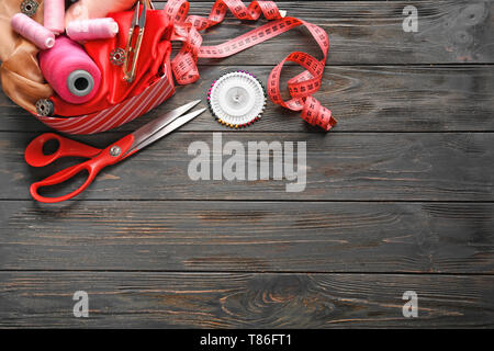 Box with color threads and sewing accessories on wooden background Stock Photo