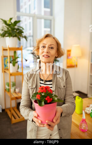 Nice good looking woman standing with a flower pot Stock Photo