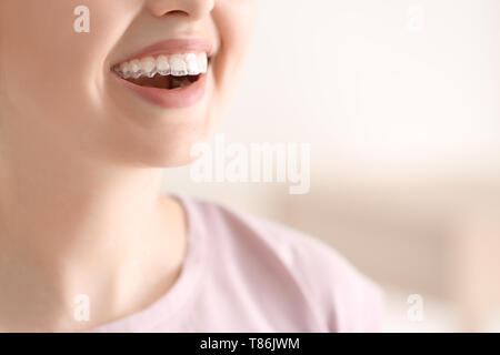 Woman with occlusal splint on light background, closeup Stock Photo