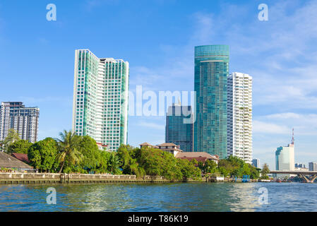 BANGKOK, THAILAND - JANUARY 01, 2019: Modern high-rise apartment buildings on the banks of the Chao Phraya River on a sunny day Stock Photo