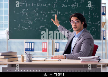 Young handsome math teacher in classroom Stock Photo
