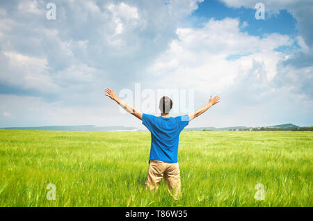 Man in green wheat meadow and sunshine. Conceptual design. Stock Photo