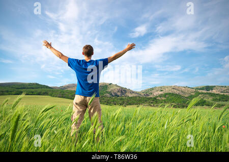 Man in green meadow at day and sunshine. Conceptual design. Stock Photo