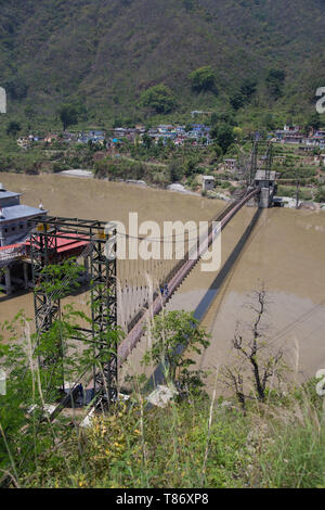 Suspension bridge in the middle of Alaknanda river near Srinagar adjoining the famous Dhari Devi temple ,Uttarakhand, India Stock Photo