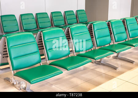 Rows of modern green chairs in waiting room lounge Stock Photo
