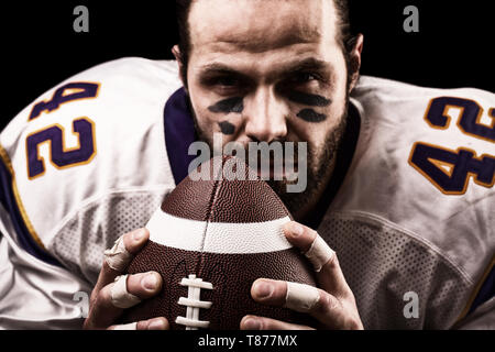 Portrait close-up, American football player, bearded without a helmet with the ball in his hands. Concept American football, patriotism, close-up. Stock Photo