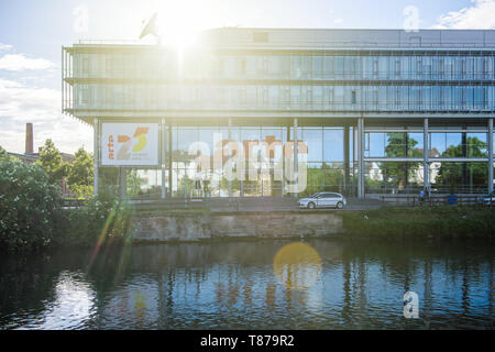 Strasbourg, France - May 19, 2017: Sunlight flare over Headquarter of Franco-German free-to-air television network that promotes cultural programming Arte televisions in Strasbourg 25 years banners on facade Stock Photo