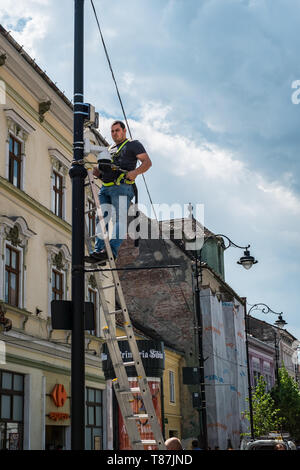 Sibiu City, Romania - 9 May 2019 A worker installs a camera surveillance on the pillar on Balcescu street, Sibiu city, Romania Stock Photo