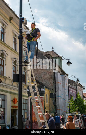 Sibiu City, Romania - 03 May 2019 A worker installs a camera surveillance on the pillar on Balcescu street, Sibiu city, Romania Stock Photo