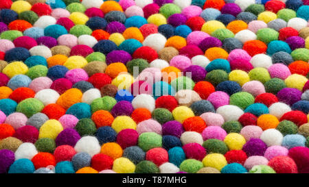 Multicolored felt ball rug detail, colorful texture Stock Photo