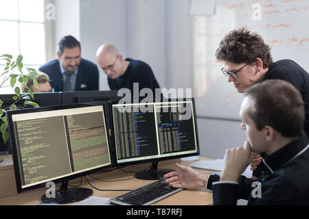 Startup business problem solving. Software developers working on desktop computer. Stock Photo