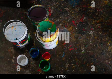 UBUD/BALI-APRIL 27 2019: colorful paint bucket with a brush and the floor is filled with beautiful solid color because the paint is scattered Stock Photo