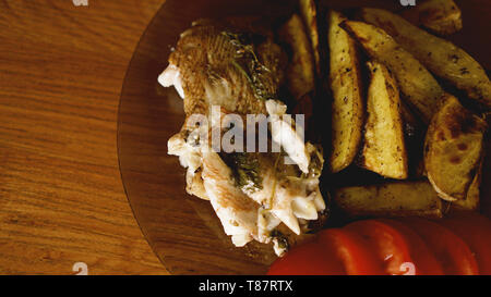 Fish dish - fried fish fillet with fried potatoes and vegetables with spices and rosemary, top view, copy space Stock Photo