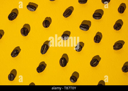 the pattern of coffee beans on bright colored background Stock Photo