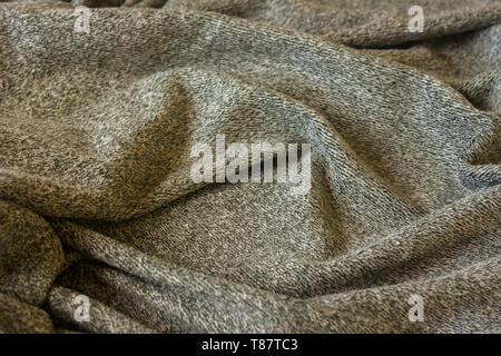 Warm fluffy grey cozy blanket. Texture of material with folds. Stock Photo