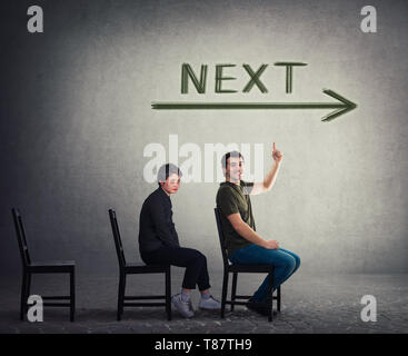 Unemployed persons sitting on chairs as candidates for a vacant job place waiting to be hired. Guy is next for employment interview. Business career d Stock Photo
