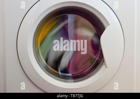Washing machine door with rotating garments inside Stock Photo