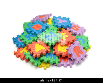 Pile of colorful foam alphabet puzzle pieces isolated on white Stock Photo